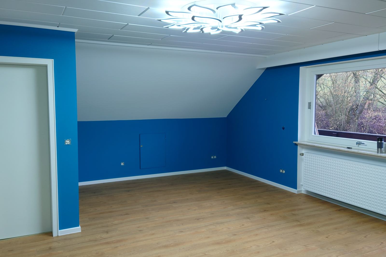Dachschraege in Blau und Weiss mit frisch lackierten Fensterlaibungen