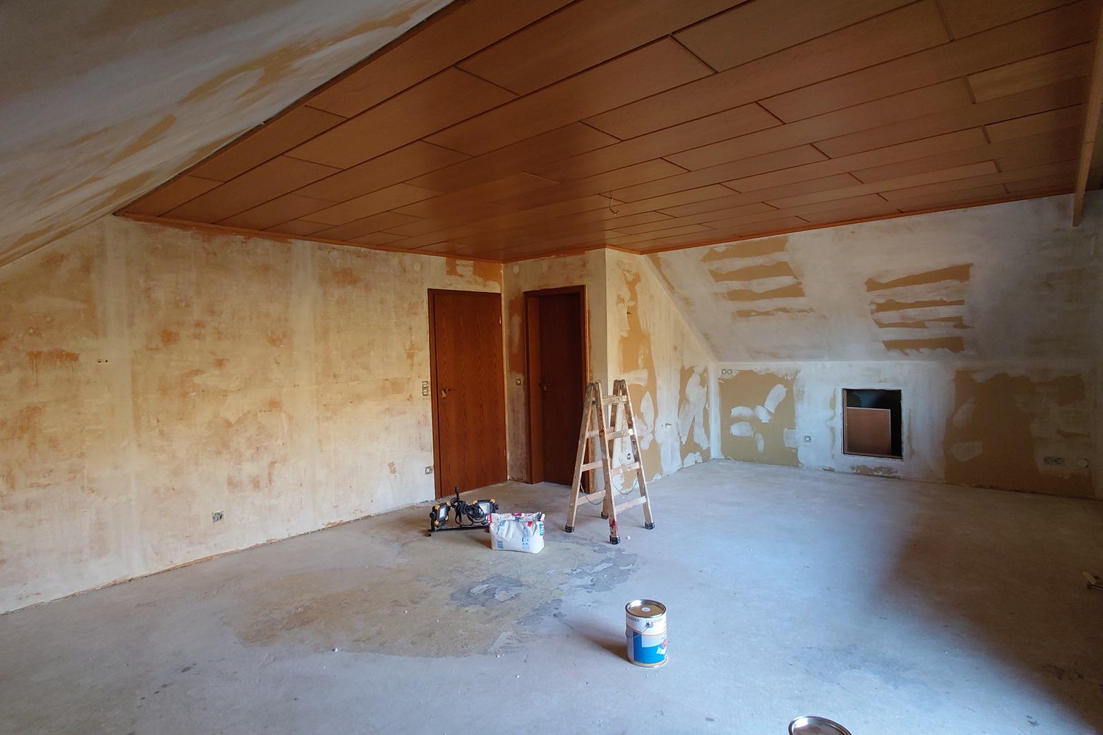 Dachzimmer mit alter Holzdecke und unverputzten Waenden vor den Malerarbeiten