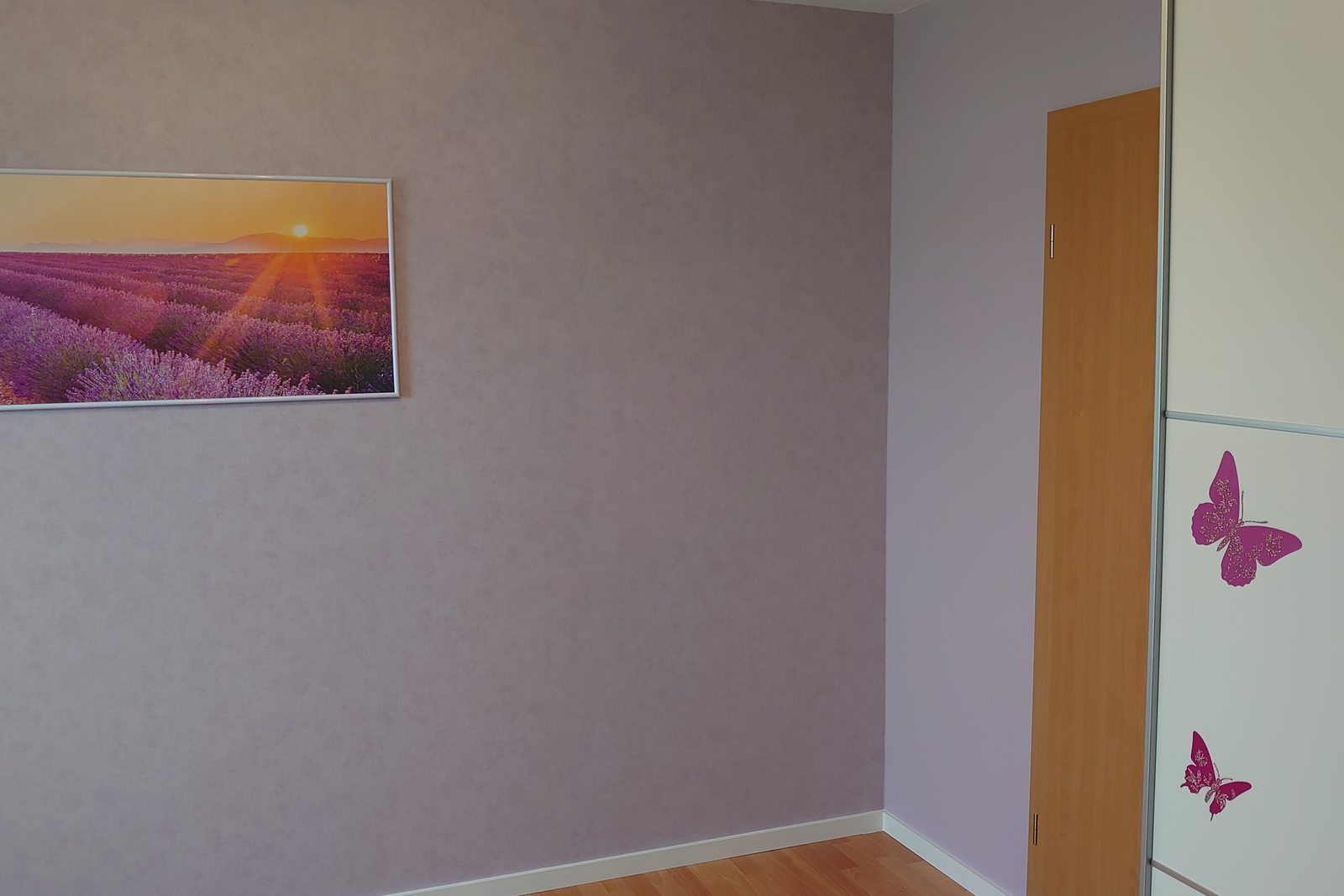 Tapezierte Wand mit Wandbild und weissem Einbauschrank